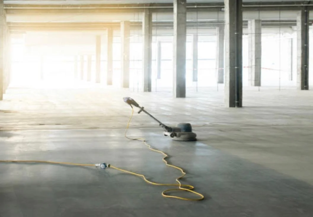 A vacuum in the middle of a concrete floor in the middle of a construction site