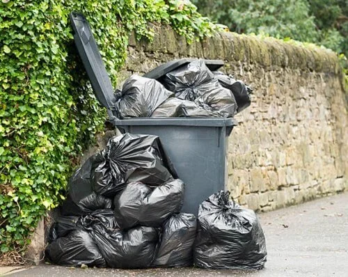 A trashcan overfilled with garbage