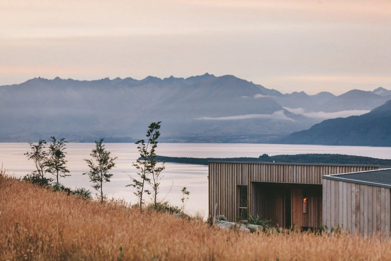Wood house with a lake and mountains in the background