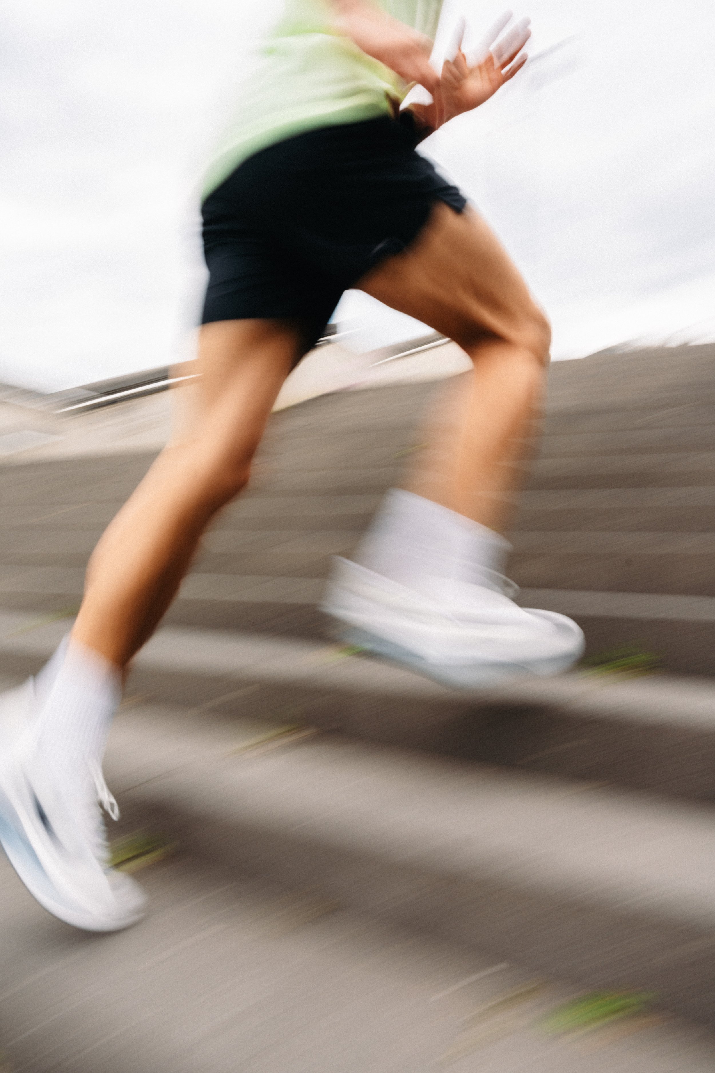 Ältere Person läuft schnelle Spaziergänge oder Joggen auf einer Straße, sichtbar durch Bewegung und verschwommene Beine.