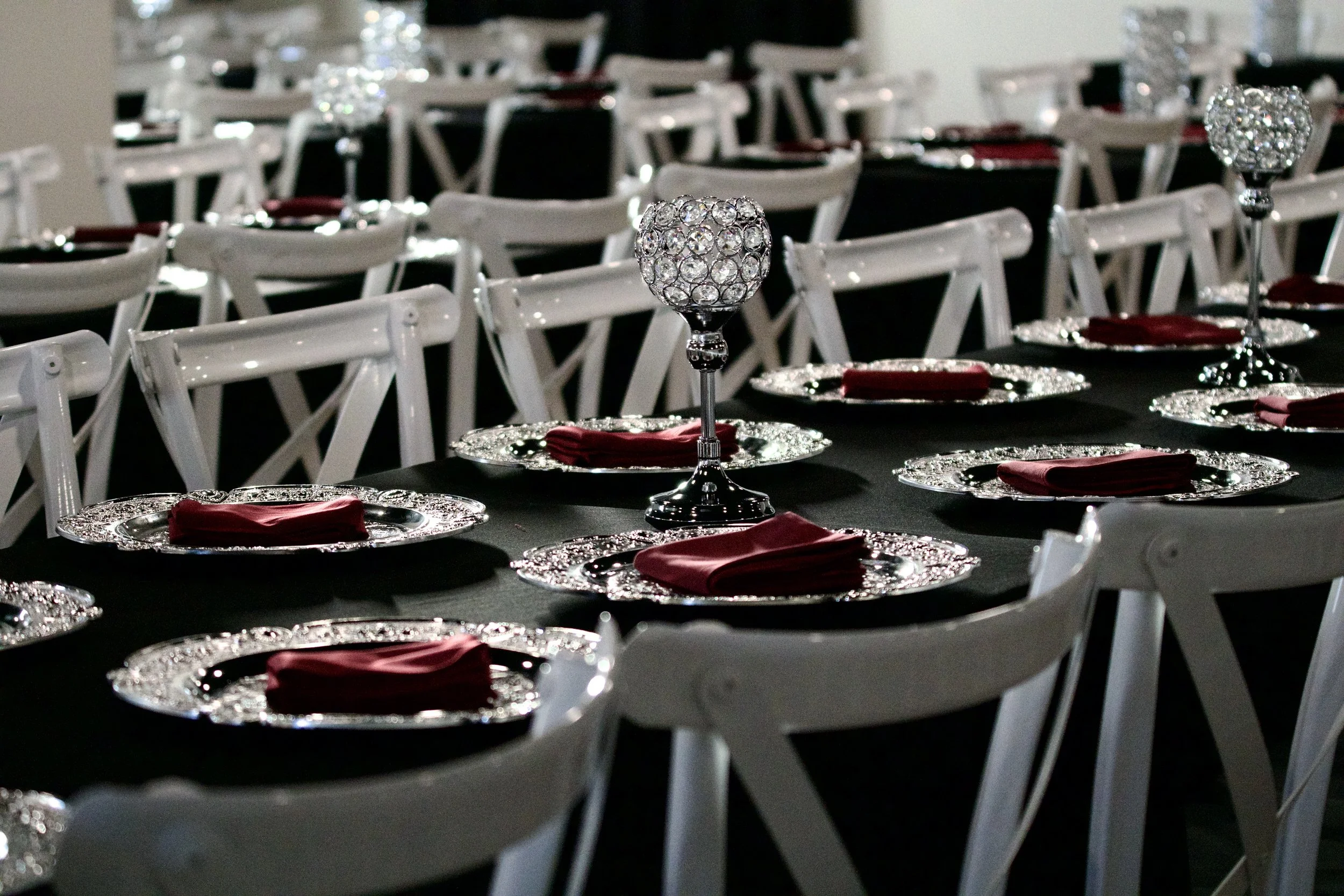 crystal ball centerpiece standing above rows of silver charger place settings