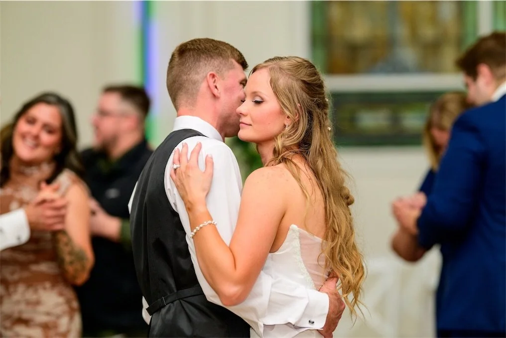 couple-dancing-cheek-to-cheek-reception-guests