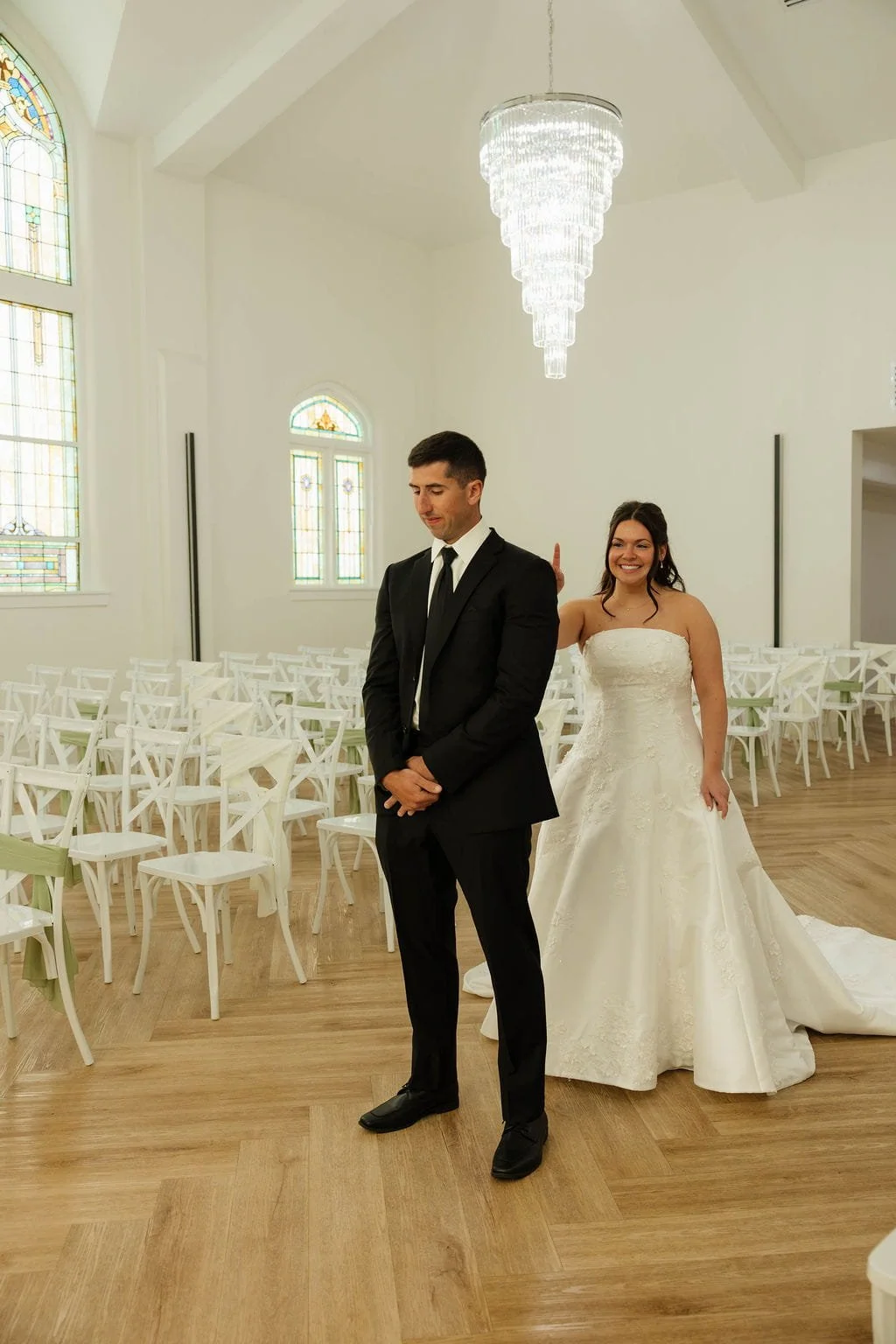 groom-eyes-closed-bride-stands-behind-taps-on-shoulder.jpg
