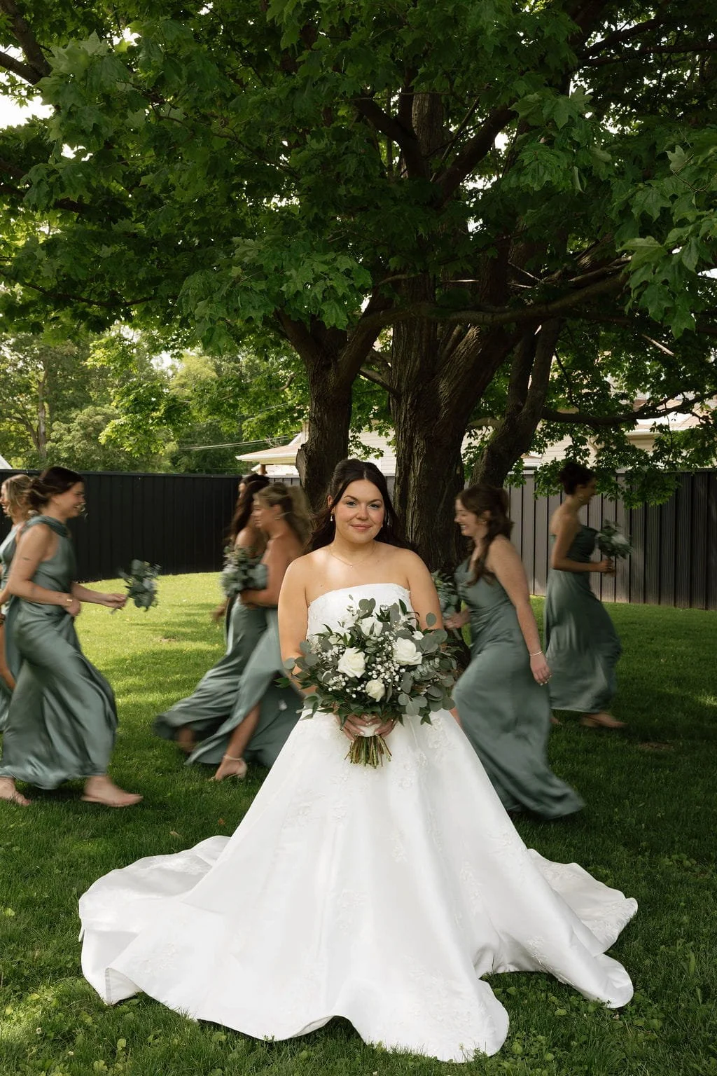 bridesmaids-walking-behind-bride-outside-under-tree.jpg