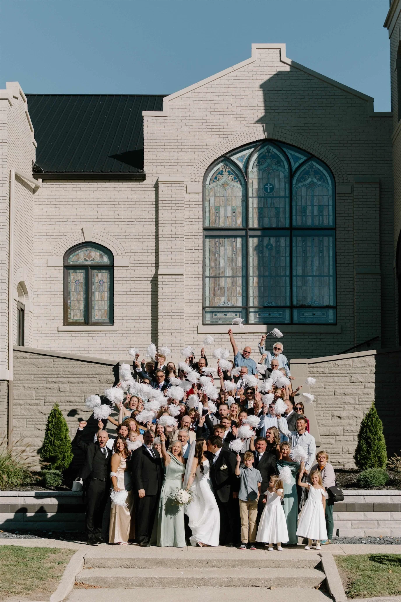 guests-cheering-pom-poms-chapel-facade-group-photo.webp