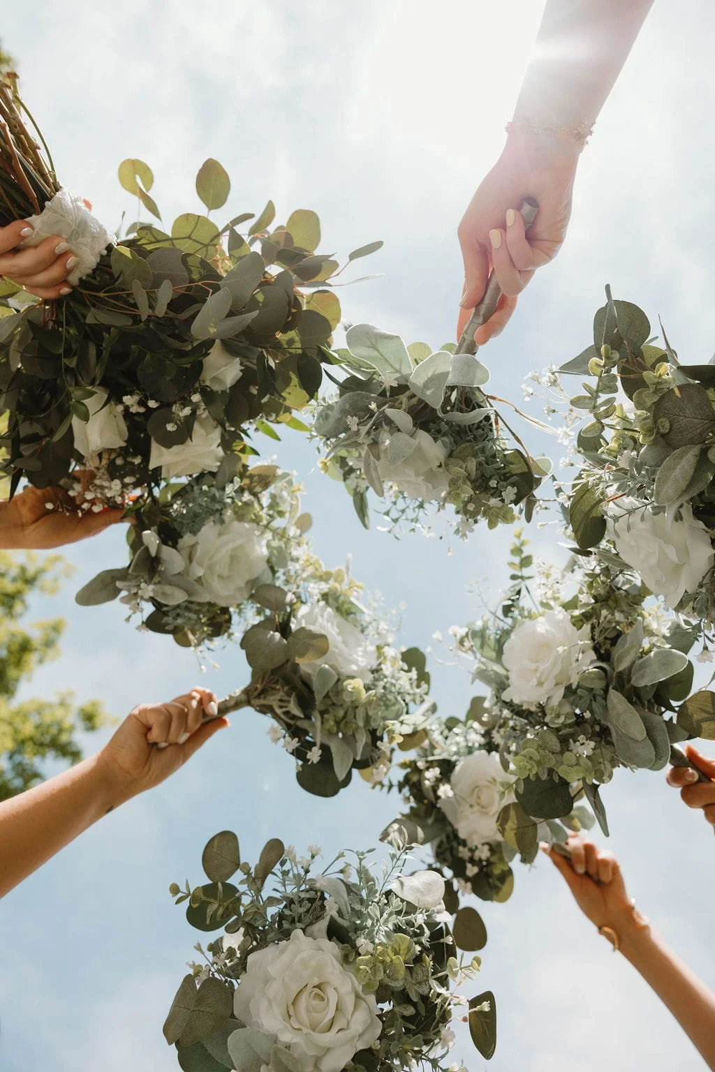 bridesmaids-raising-white-rose-bouquets.jpg