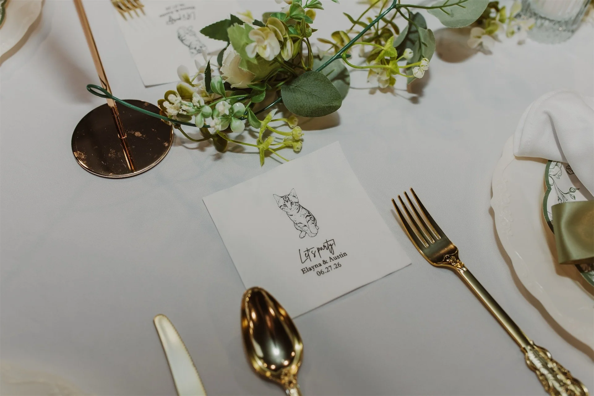 Wedding table setting with illustrated place card and gold flatware