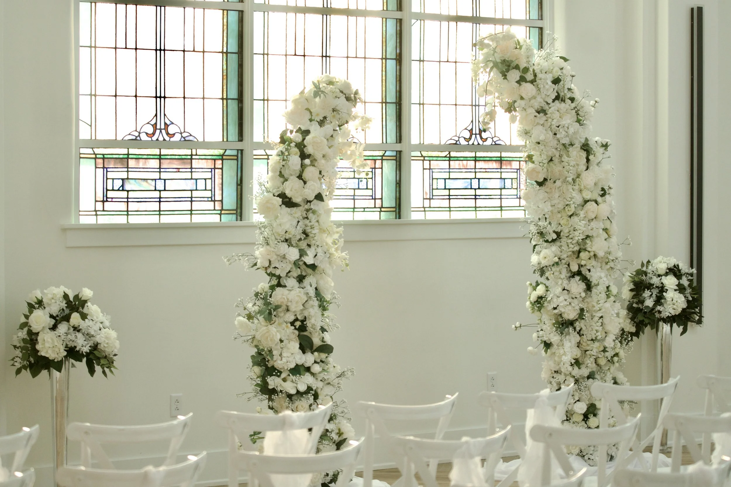 tall white floral pedestal arrangements lining the ceremony aisle at Kaleidoscope