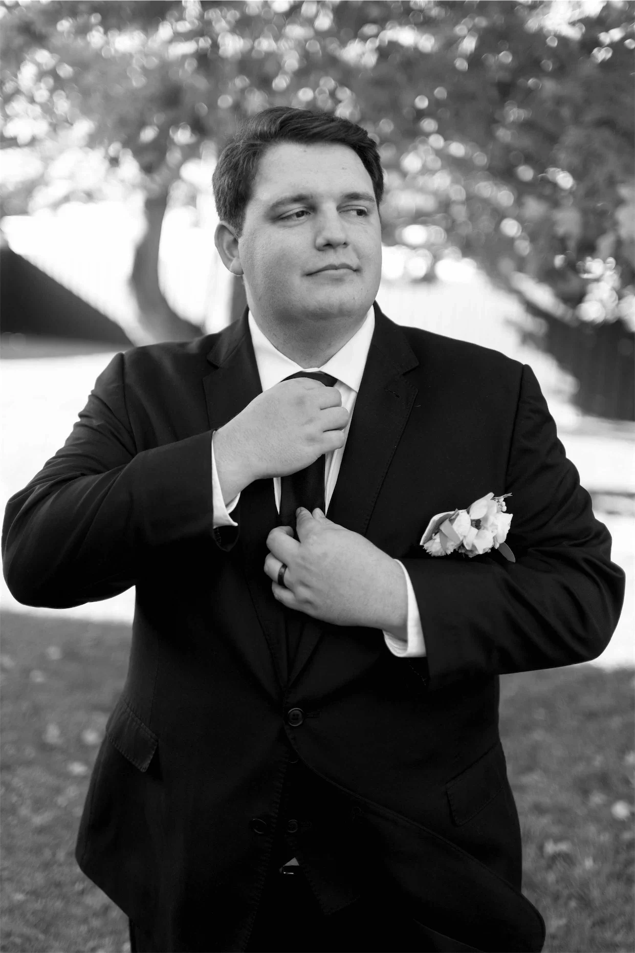 groom-adjusting-tie-portrait-black-and-white.webp