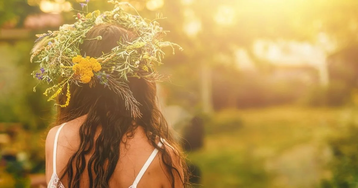 Bride wearing wildflower crown photographed in warm summer golden hour light outdoors