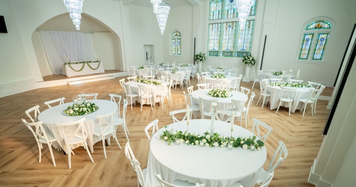 Kaleidoscope Weddings reception hall with crystal chandeliers and stained glass windows set for a summer wedding