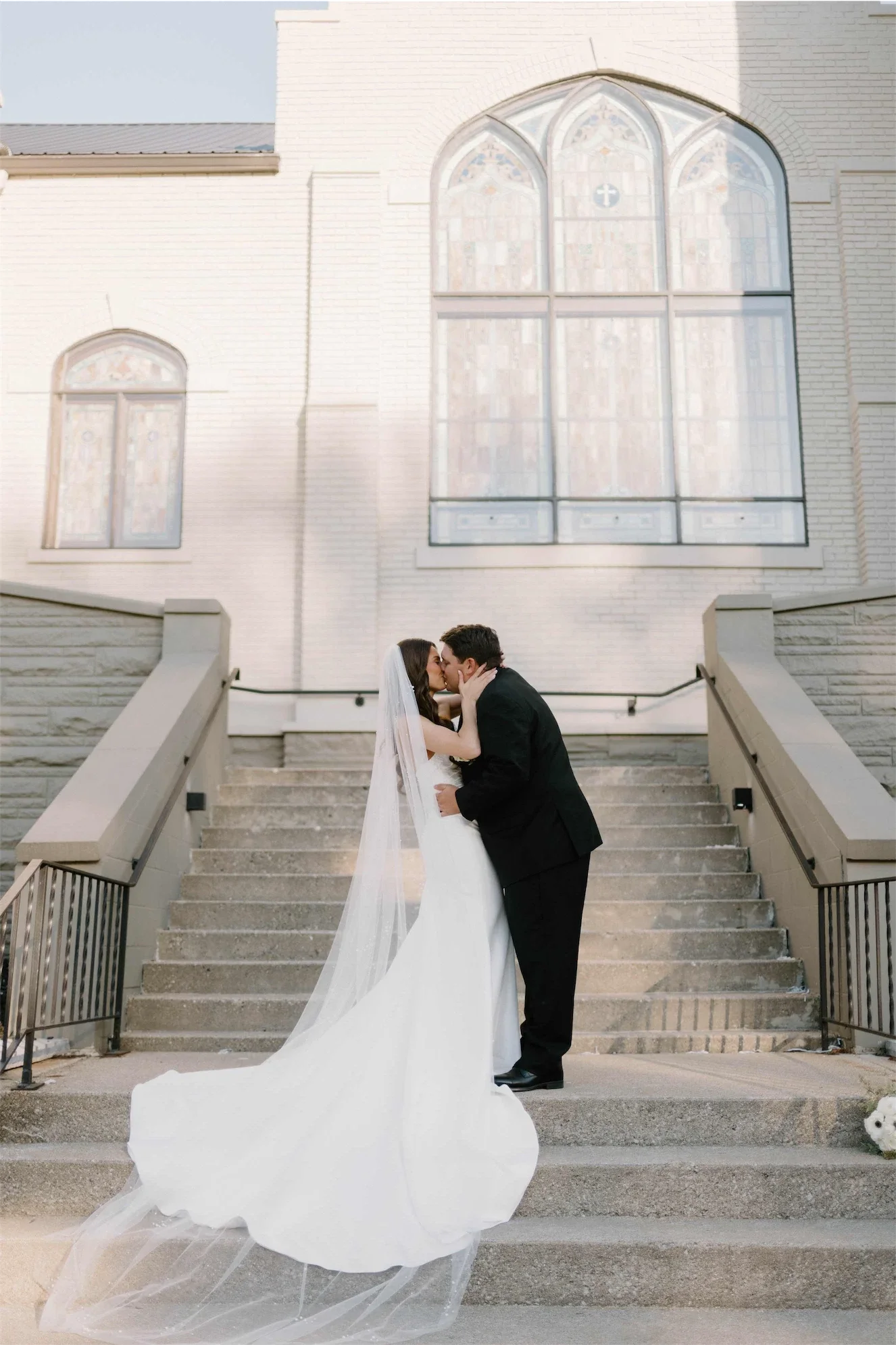 couple-kissing-chapel-staircase-stained-glass-facade.webp