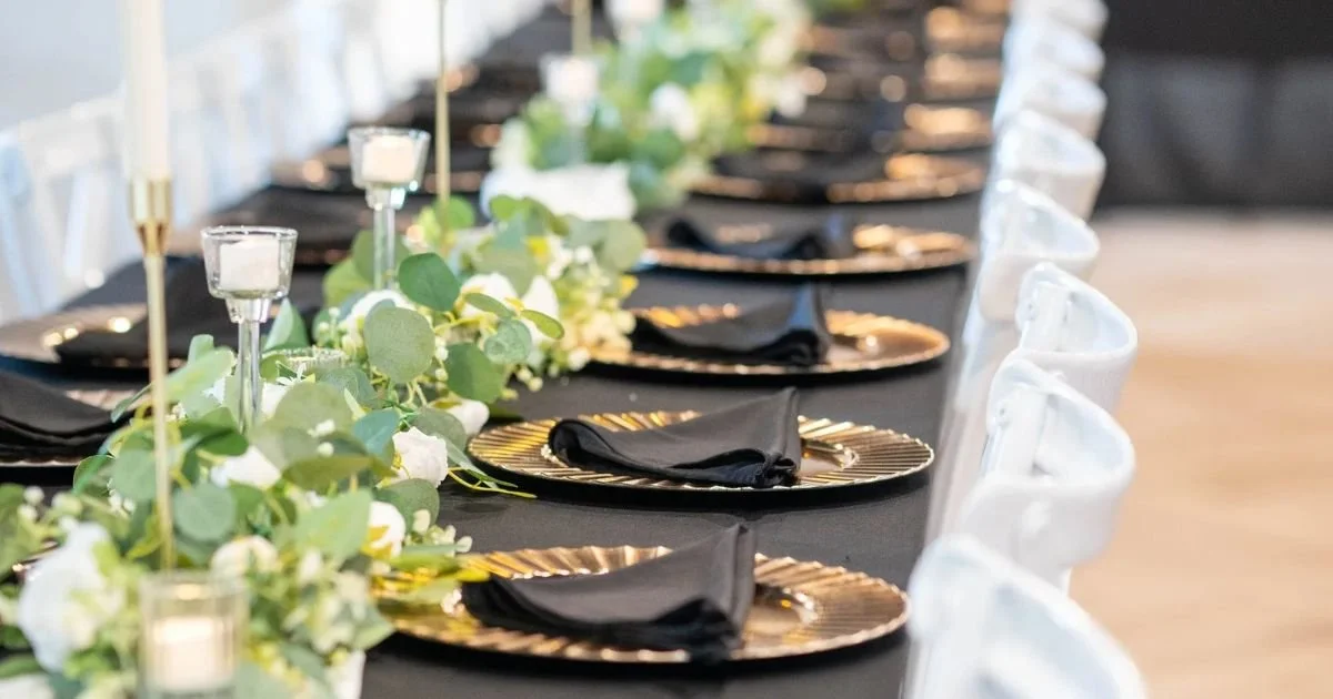floral garland and gold place settings running the length of a reception table