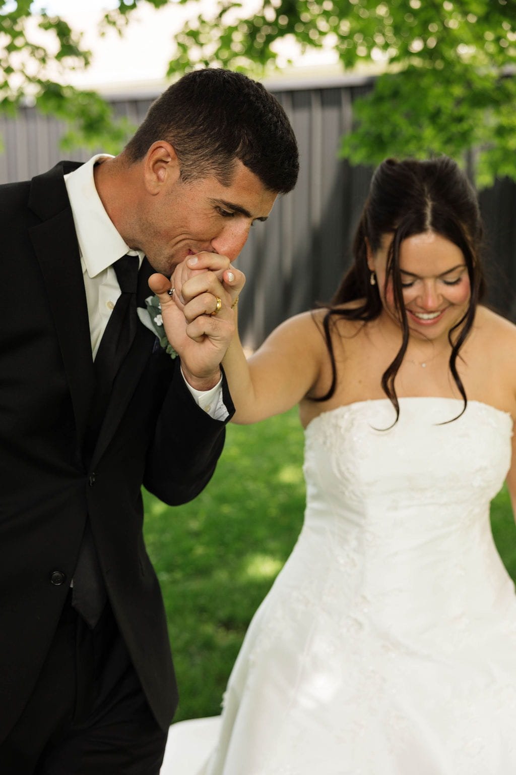groom-kissing-brides-hand-outdoor-portrait.jpg
