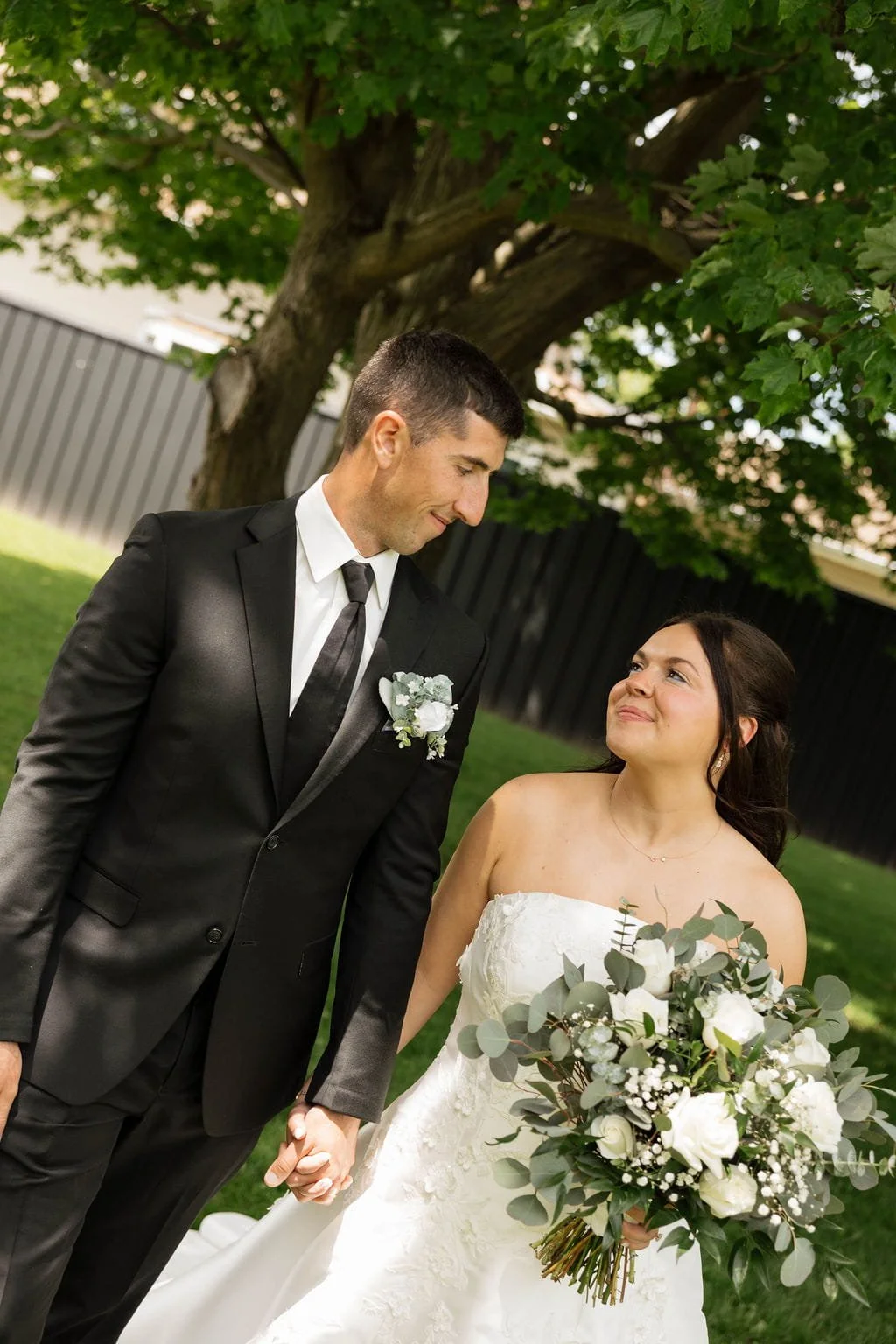 newlyweds-holding-hands-under-tree.jpg