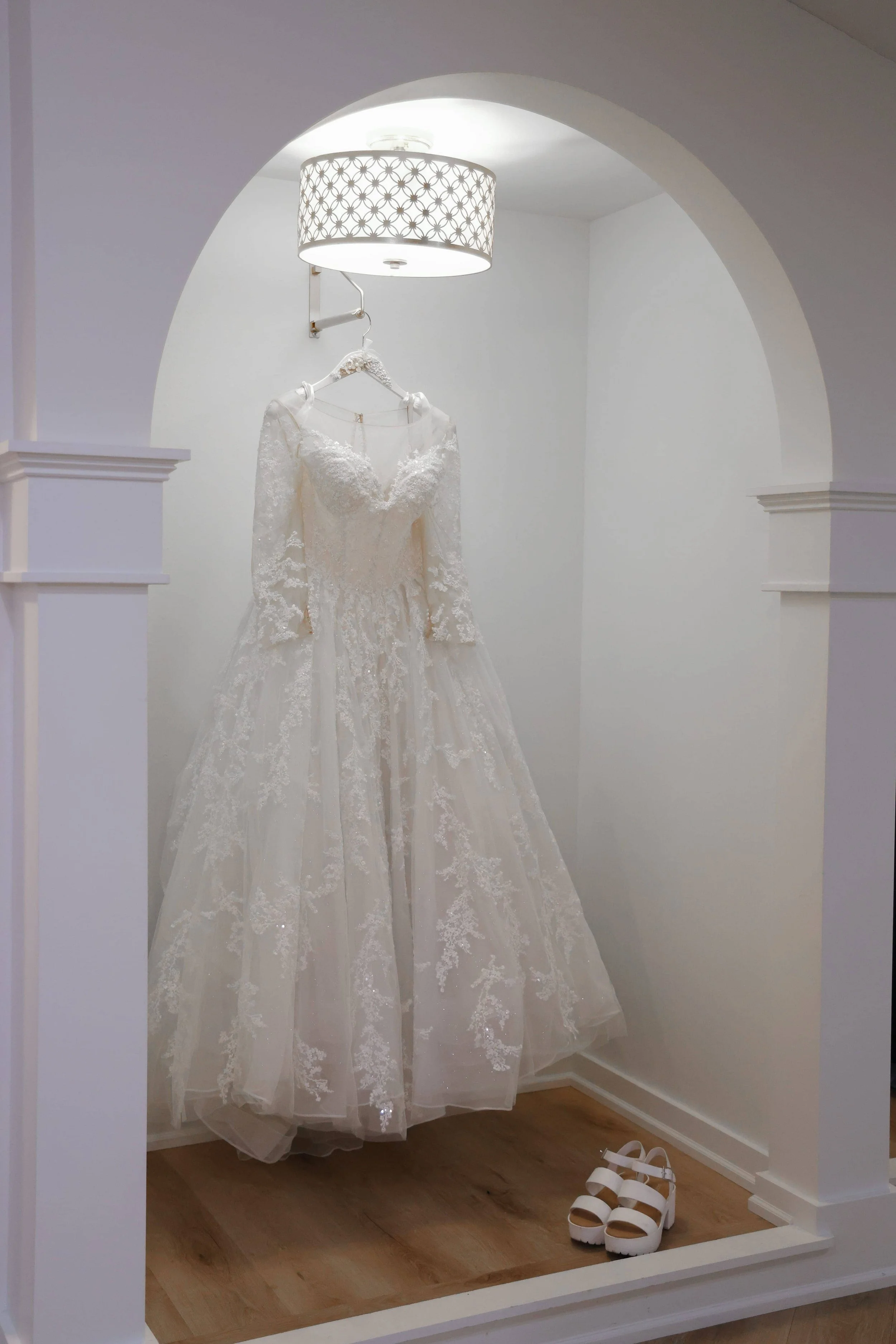 wedding-dress-hanging-arched-doorway-shoes.jpg