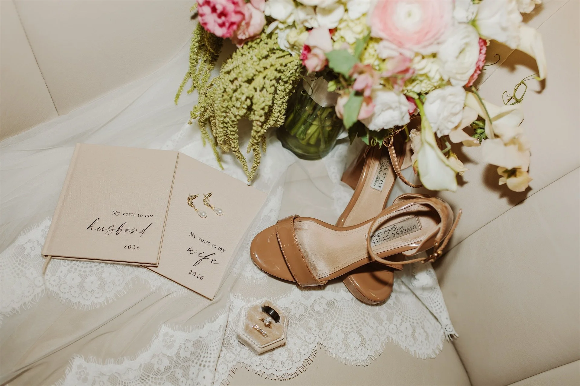 Bride and groom vow books nude heels and wedding rings styled together