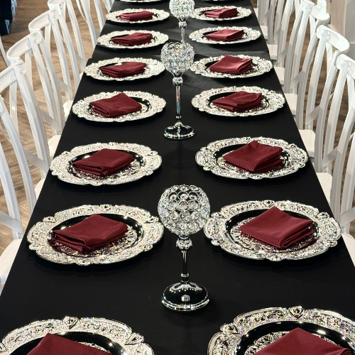 overhead view of crystal candle holders spaced between silver charger place settings
