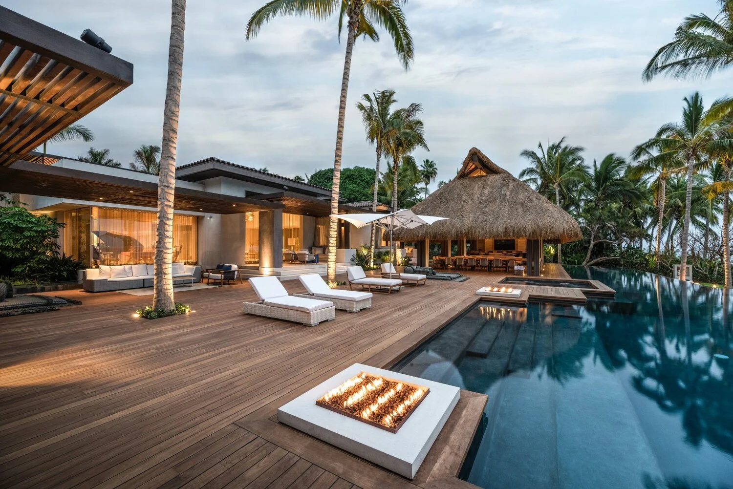 Sunset scene with beach chairs over looking the ocean with a cliff in the background