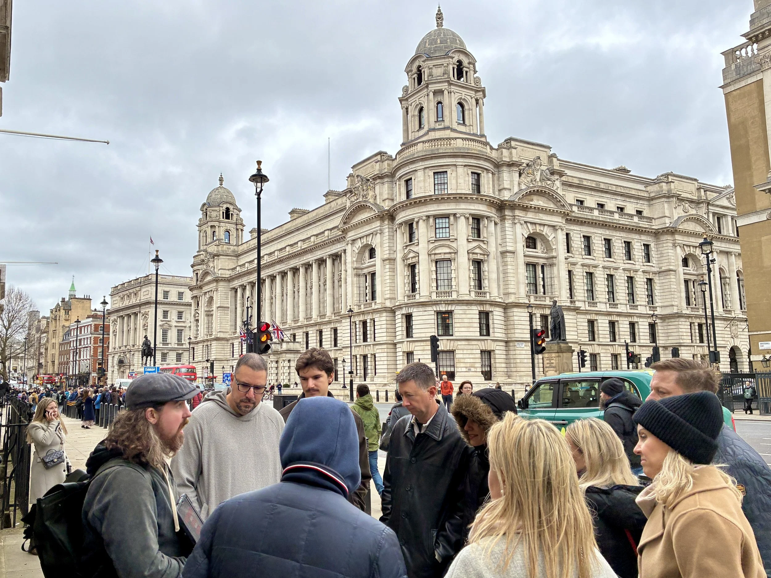A walking tour group standing in Central London while the tour guide talks about the history of espionage in the city.