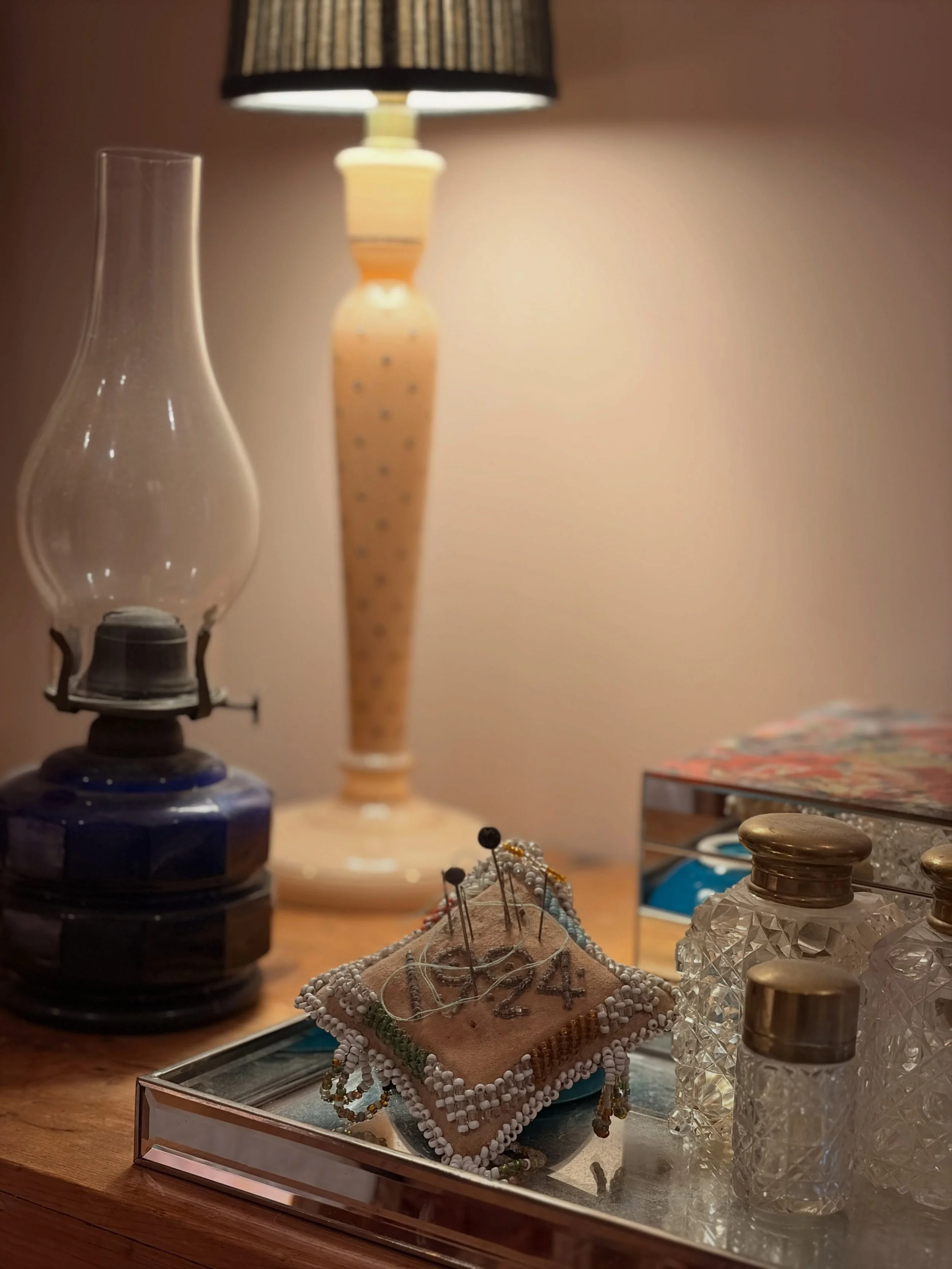 My grandmother&rsquo;s brass topped perfume bottles and hand beaded pin cushion from 1924, with my dad&rsquo;s cobalt blue glass oil lamp. Pink glass lamp junk shop &euro;5 find. #eclecticinteriors #rainydayrearranging #autumnvibes🍁
