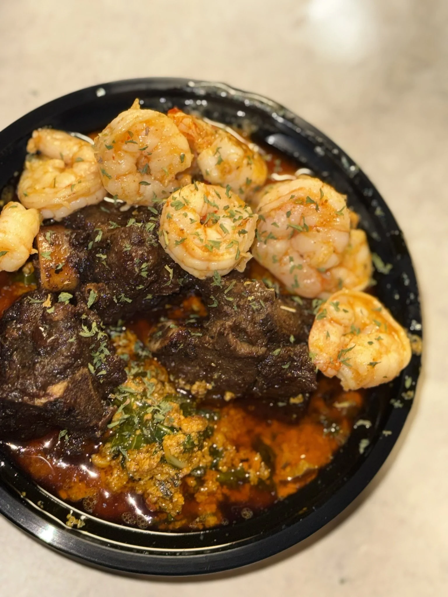Plate of shrimp with herbs, beef stew, and seasoned ground meat in sauce, garnished with parsley.