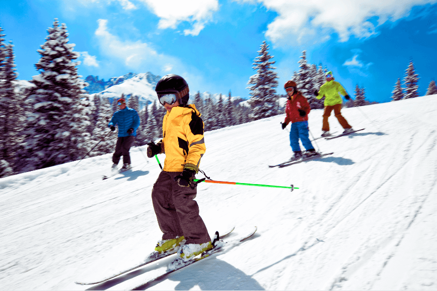 People downhills skiing on a beautiful day