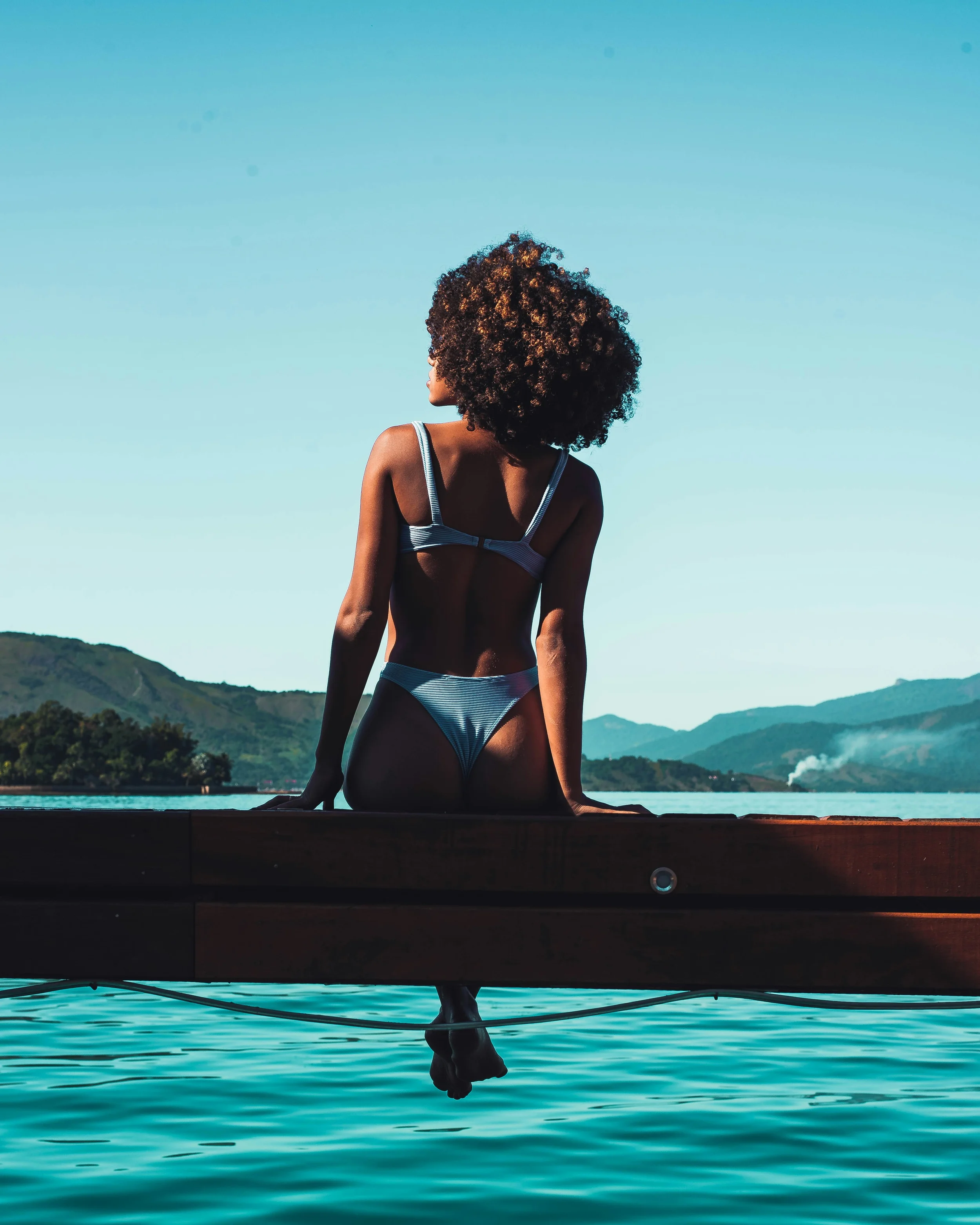 photo of person in a bathing suit sitting by a pool