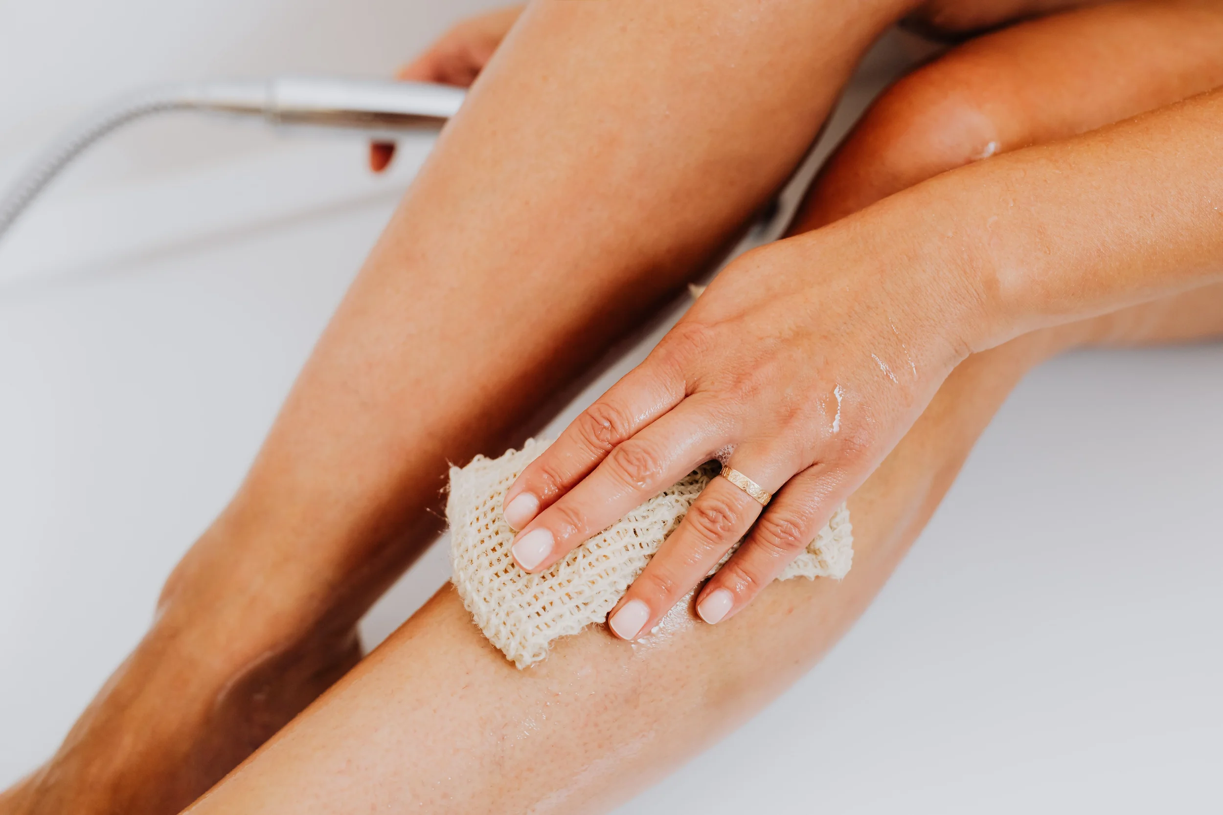 photo-of-a-person-using-an-exfoliating-cloth-to-scrub-their-legs