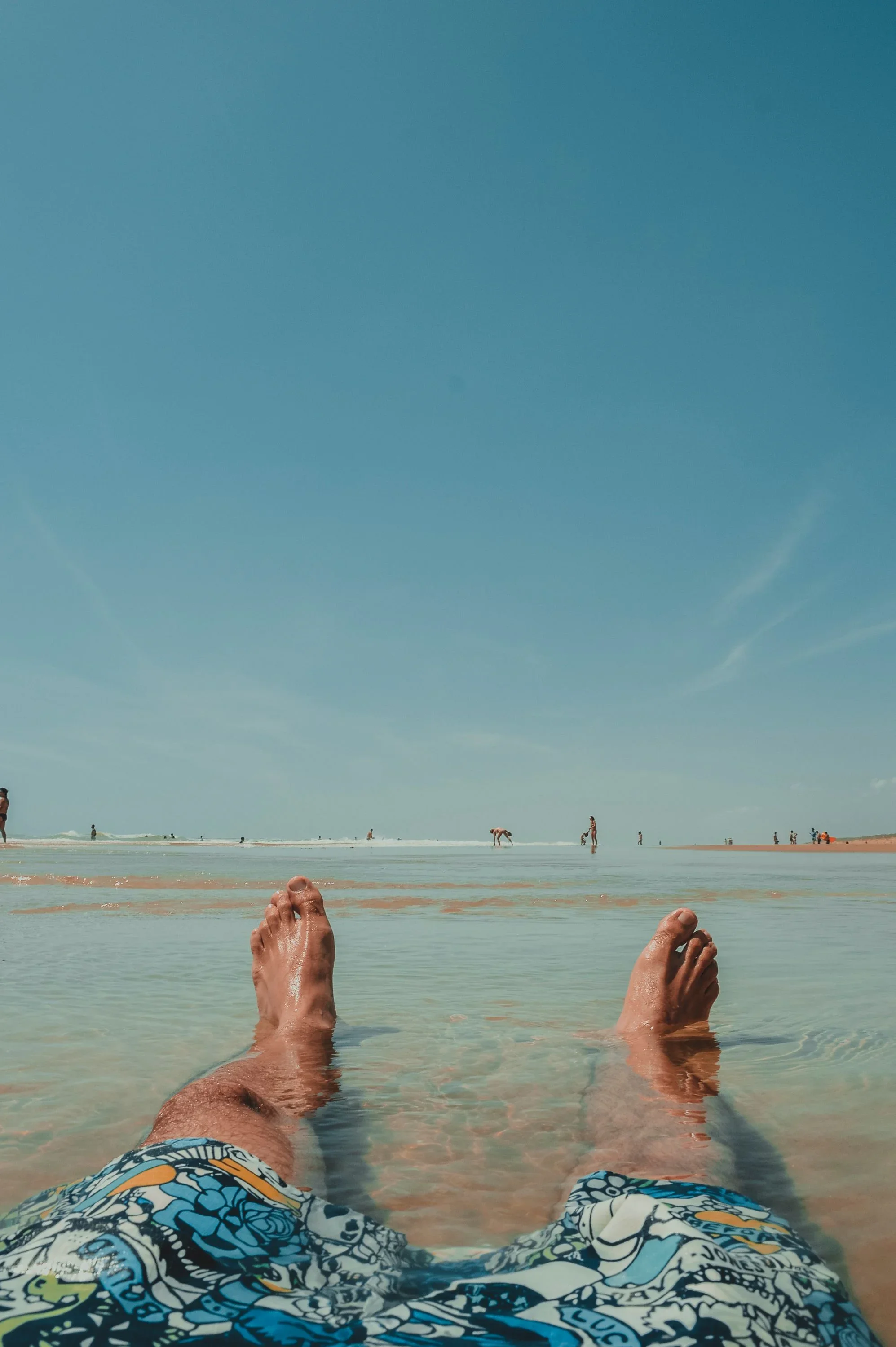 photo-of-a-man-looking-at-his-feet-while-lounging-on-a-beach