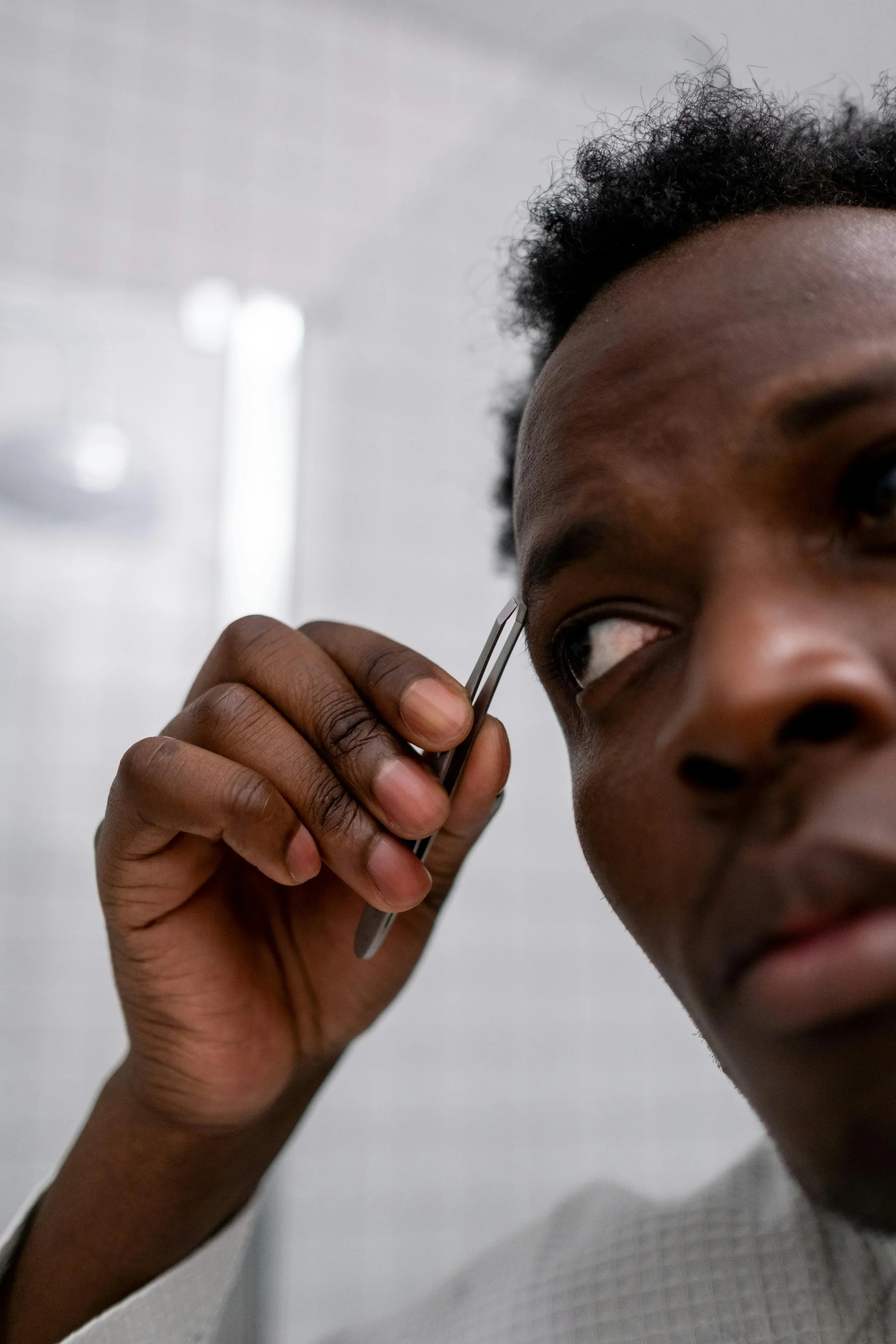 Man plucking his eyebrows