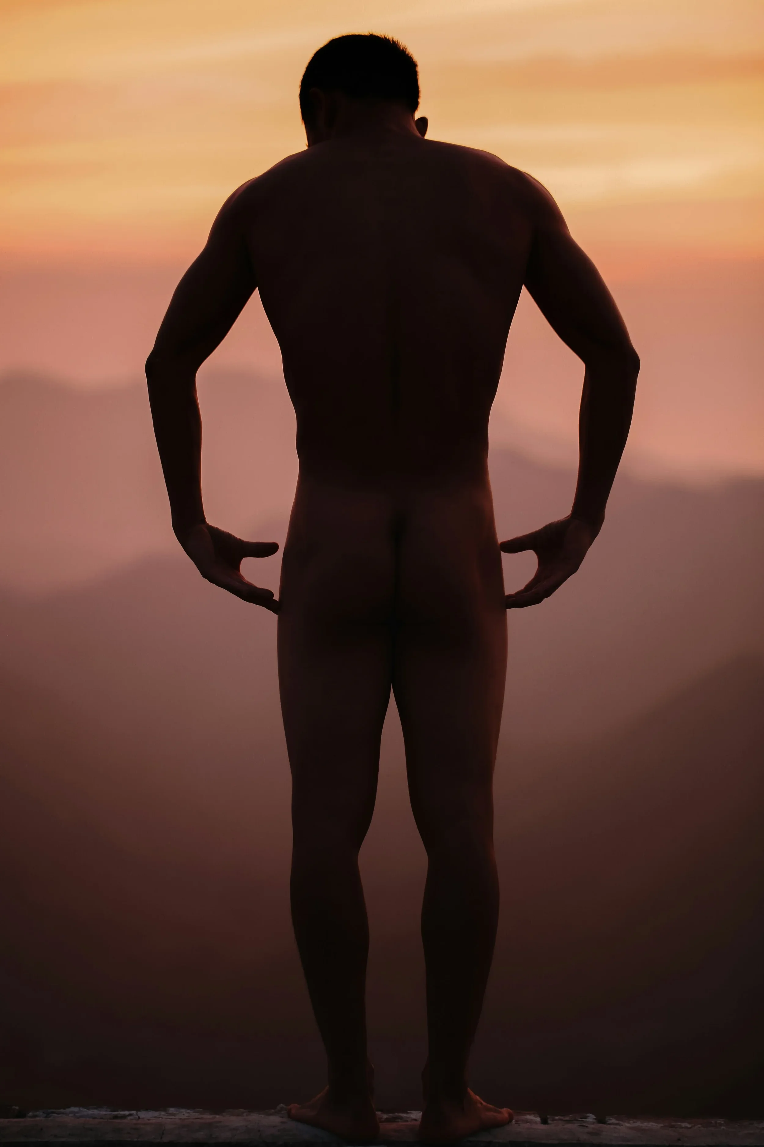 photo of a man at sunset gesturing towards his butt
