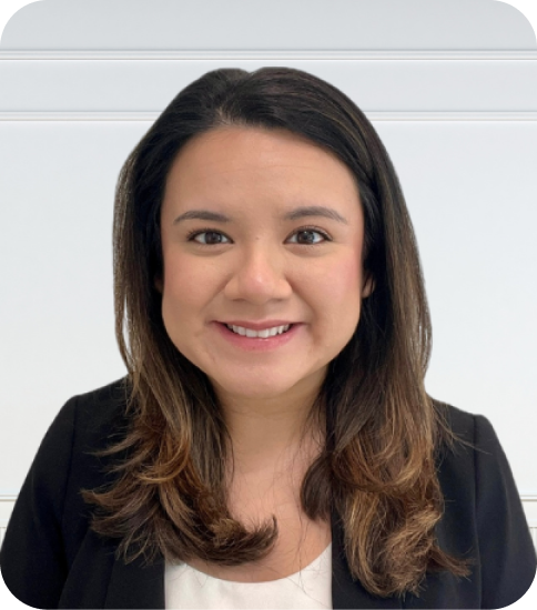A woman smiling with shoulder-length brown hair, wearing a black blazer and white top, in front of a white background with horizontal lines.