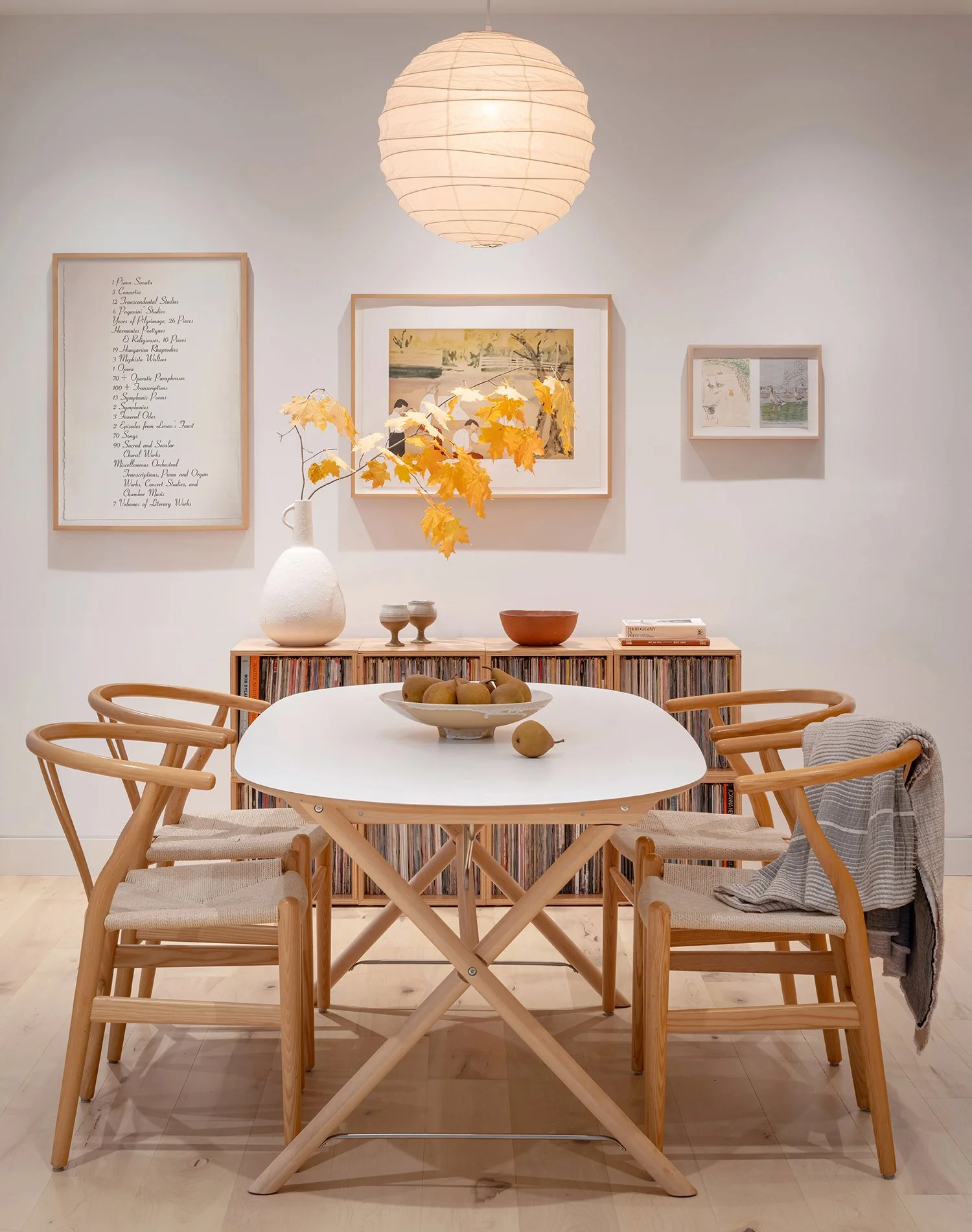 The dining room is enhanced with maple flooring, a Noguchi lamp, and carefully selected art pieces.