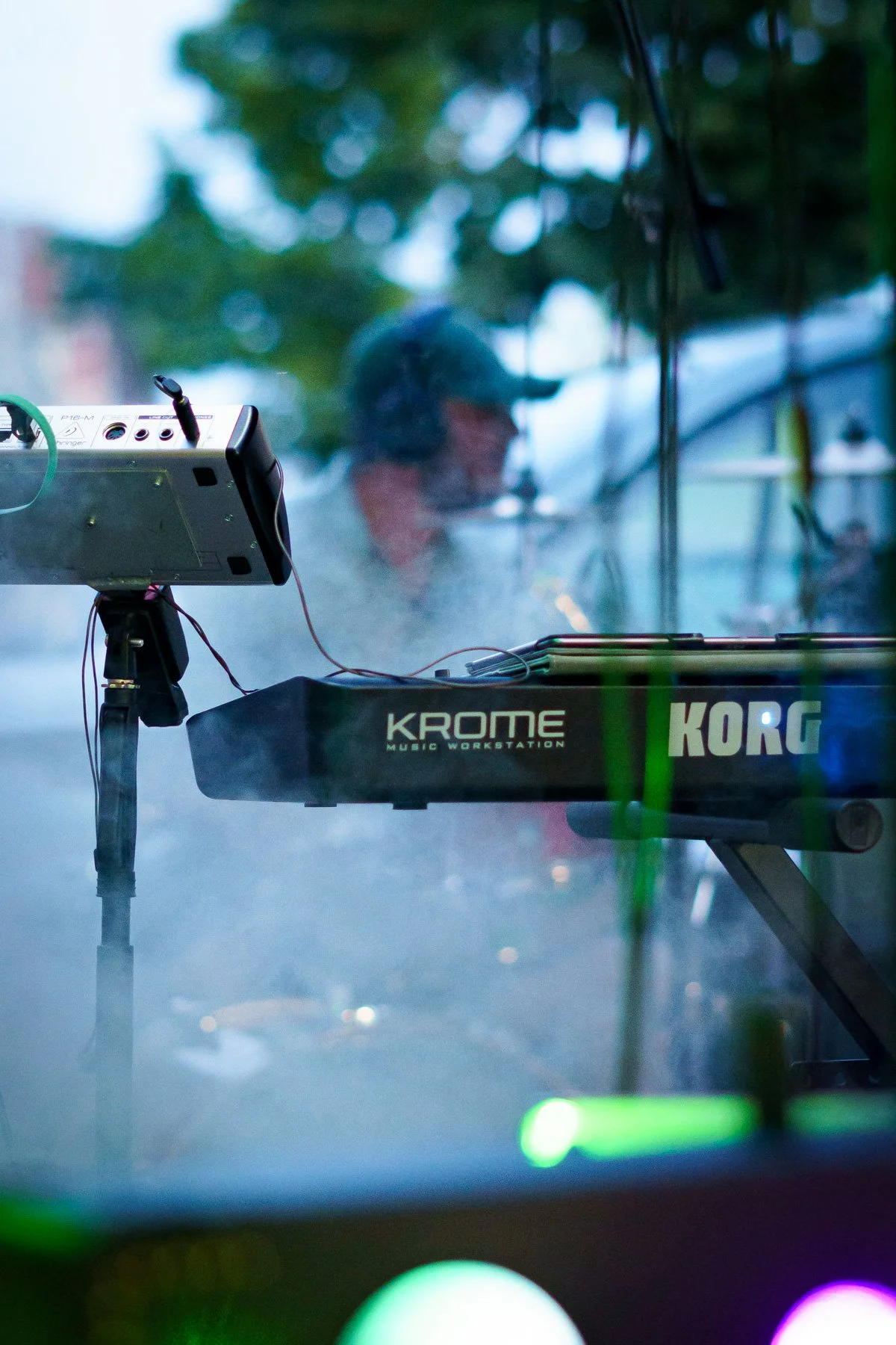 Clavier Korg Krome sur scène avec fond flou et effets de lumière.