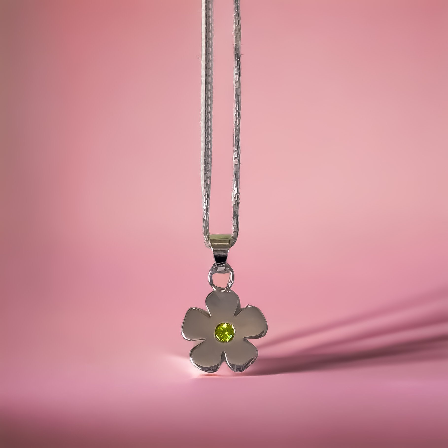 Soft flower pendant set in August birthstone green peridot.