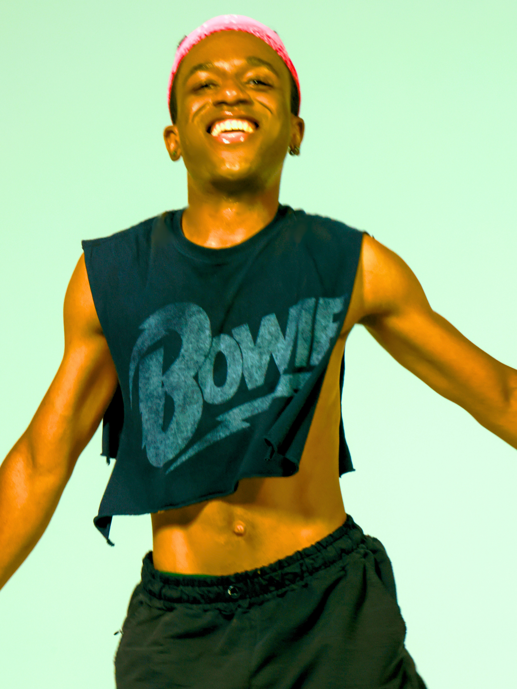 Young woman with short blonde hair and a lip piercing sitting in a car, wearing a black t-shirt and a silver chain necklace.