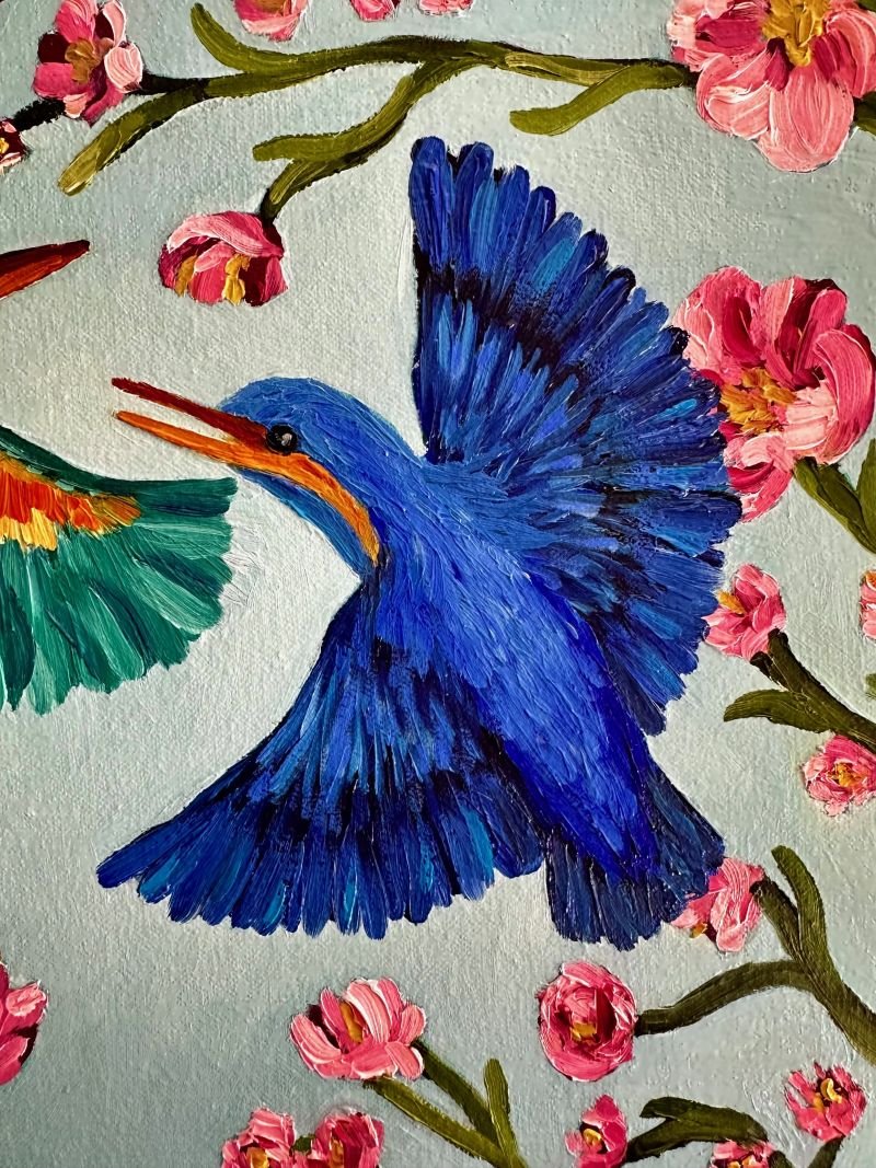 Kingfishers in Flight is an original oil painting by Australian artist Cassie Holmes, and features three beautiful kingfisher birds flying amongst some beautiful soft pink flowers.