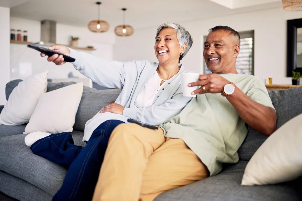 Smiling older couple relaxing together on their sofa at home