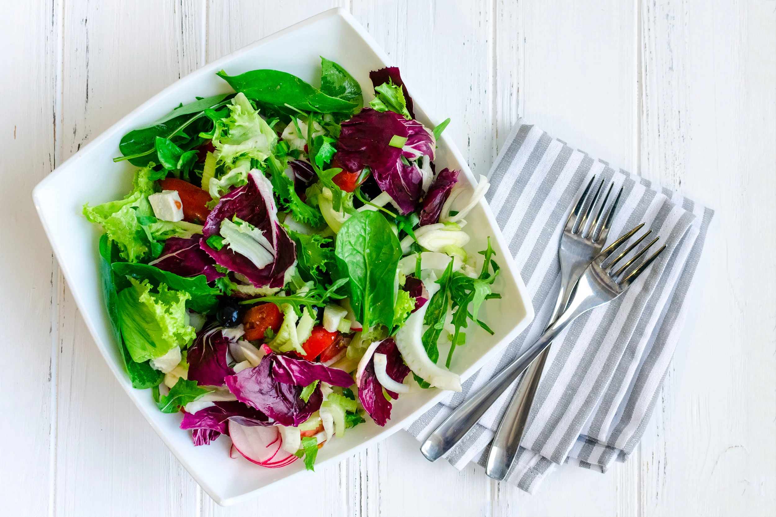 Fresh-summer-green-salad-mix-on-a-wooden-table-859364404_2528x1686.jpeg