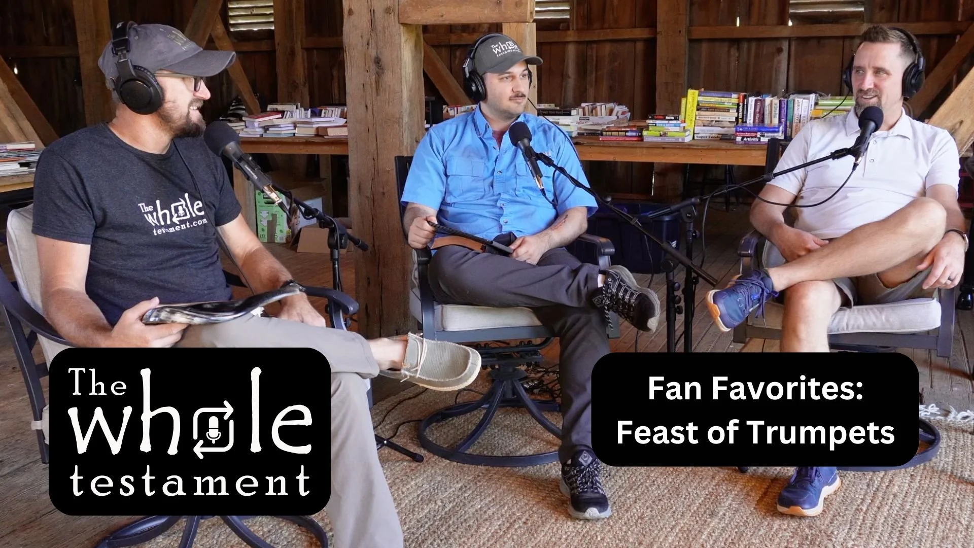 Three men sit in a rustic wooden room with bookshelves behind them, participating in a podcast recording with microphones and headphones. The man on the left wears a gray cap and t-shirt with 'The Whole Testament' logo. The man in the middle wears a blue shirt and has a neutral expression. The man on the right wears a white shirt and shorts, sitting with one leg crossed over the other. A banner with the text 'The Whole Testament' and 'Fan Favorites: Feast of Trumpets' is displayed at the bottom of the image.
