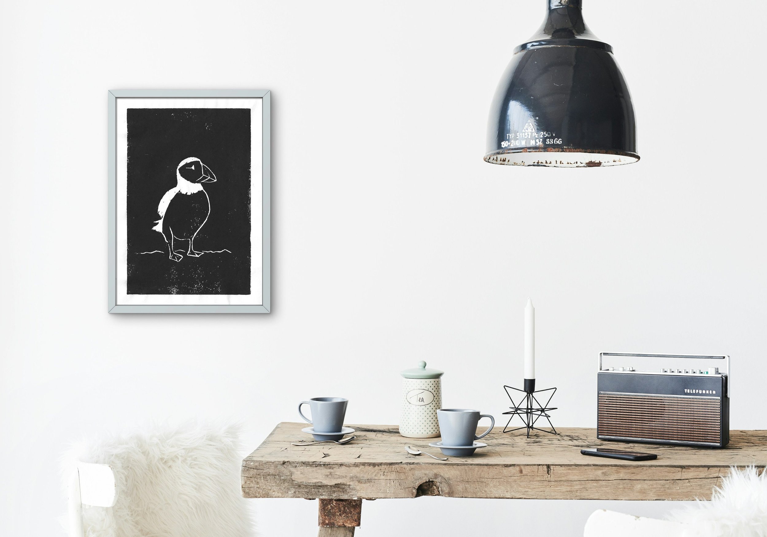 The puffin print is styled in a modern, white kitchen with minimal decor and natural light.