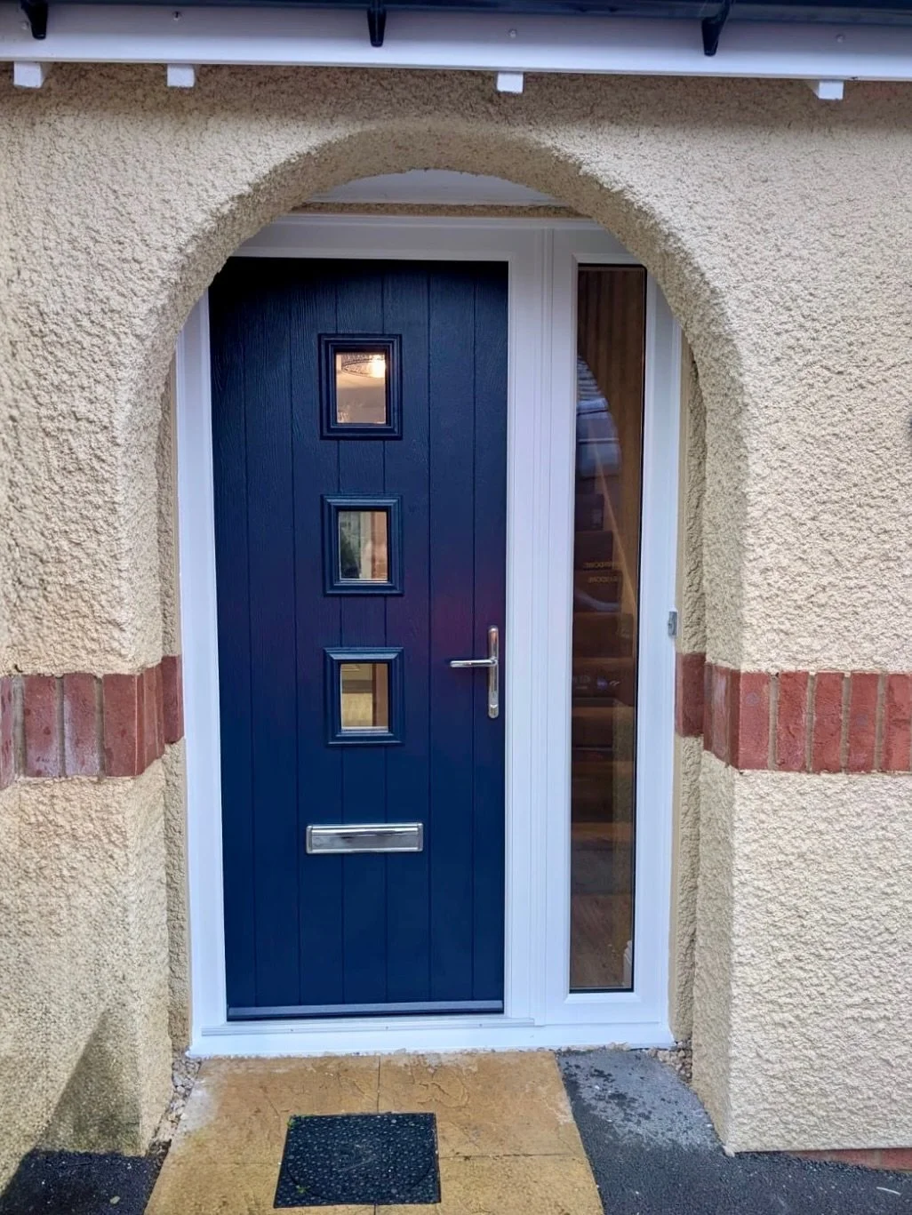 This entrance has been completely transformed with a sleek, modern door upgrade&mdash;bringing in more light, stronger security, and a bold new look. The deep blue finish, clean vertical lines, and contemporary glazing turn a dated entryway into a st