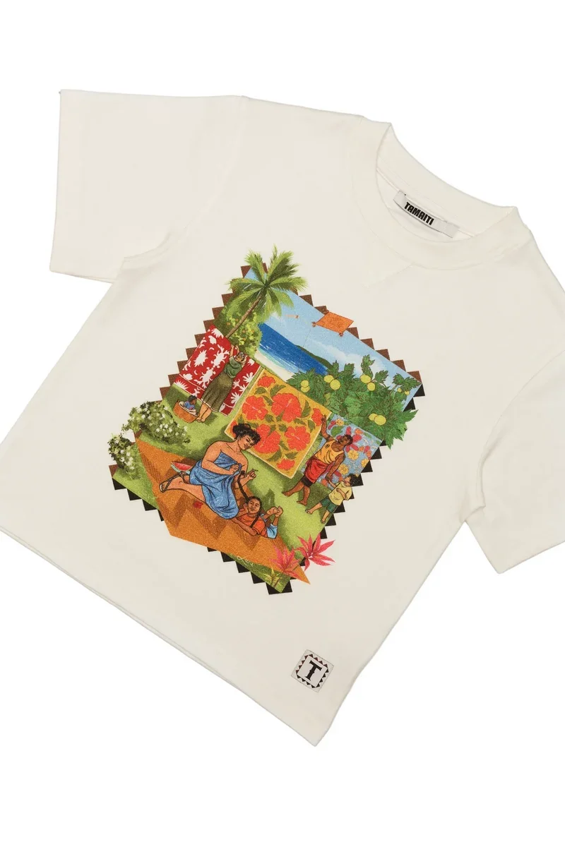 White T-shirt with a colorful graphic depicting a tropical scene with women, children, palm trees, ocean, and flowers.