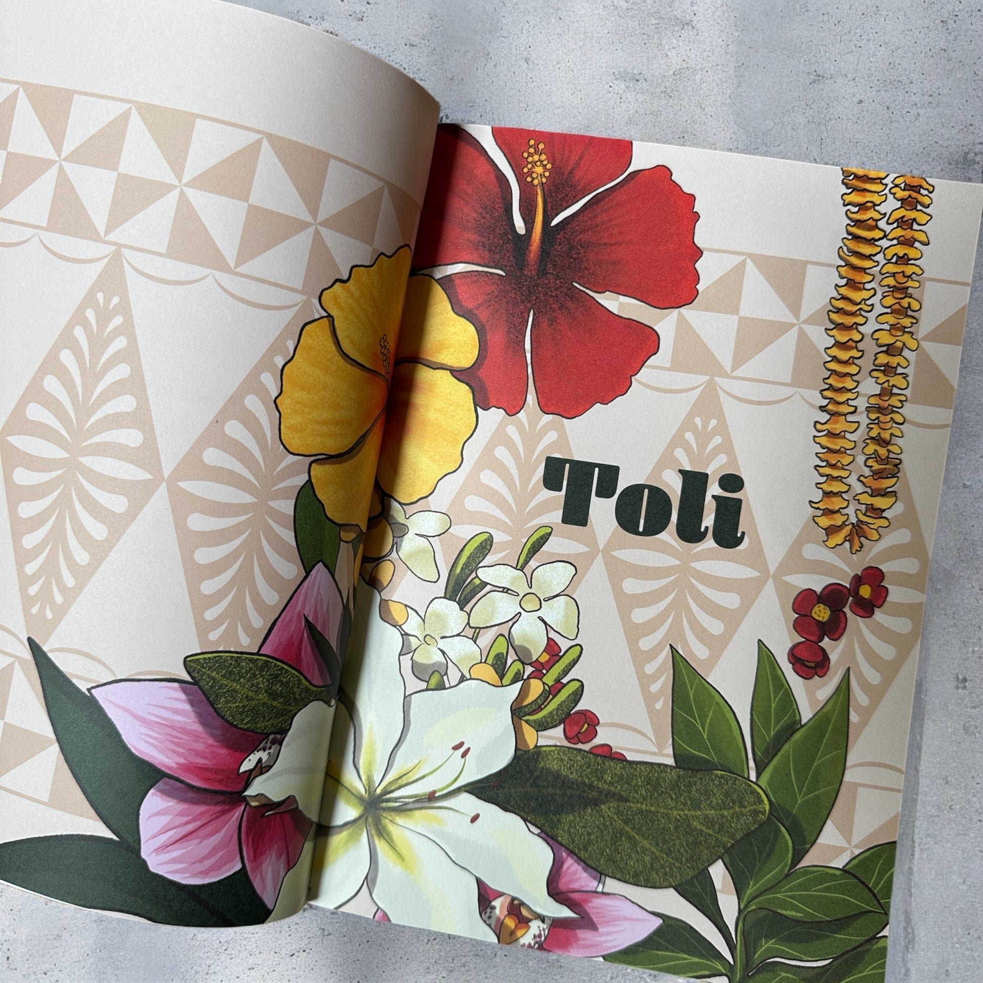 Open book featuring colorful tropical flowers, including hibiscus, with decorative background pattern and leafy accents.