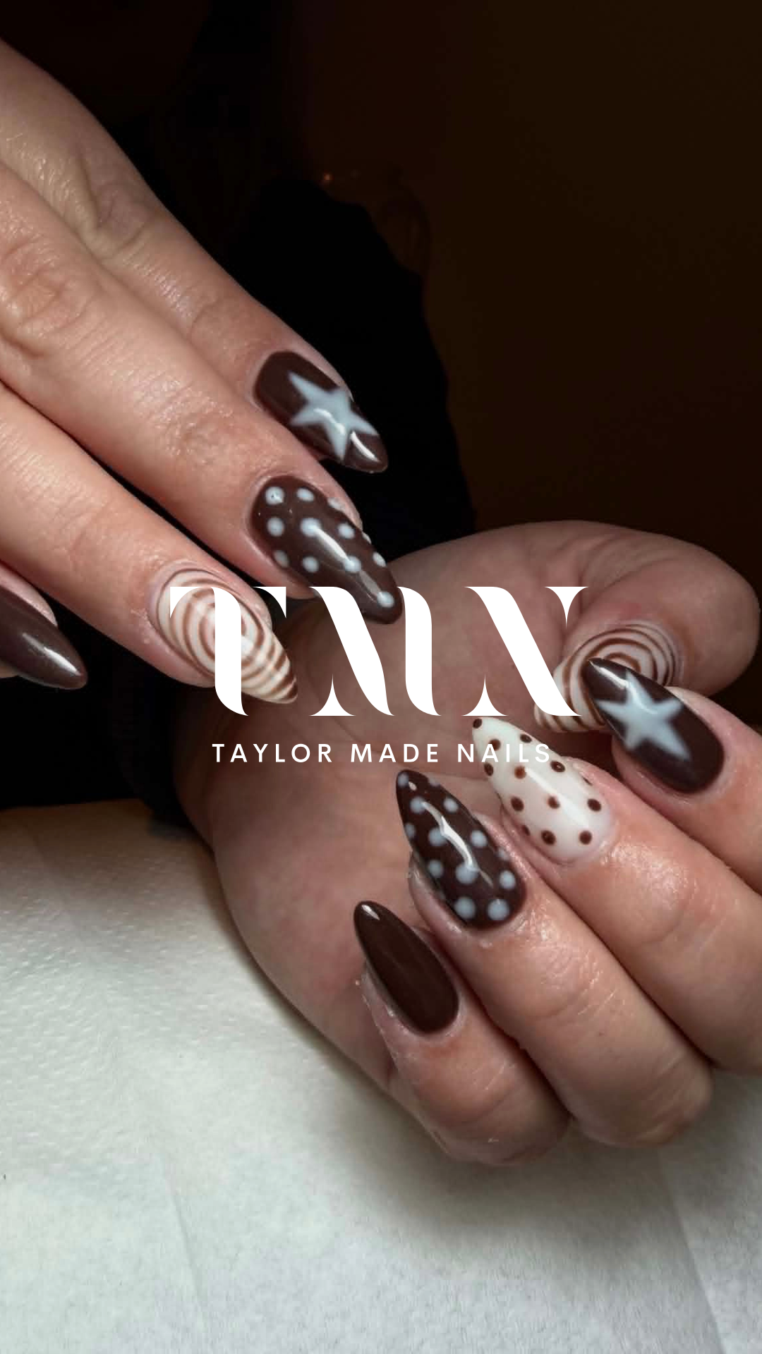 Close-up of hands with manicured nails featuring brown, white, and beige designs including stars, polka dots, spirals, and stripes, with the logo 'TAYLOR MADE NAILS' overlaid.