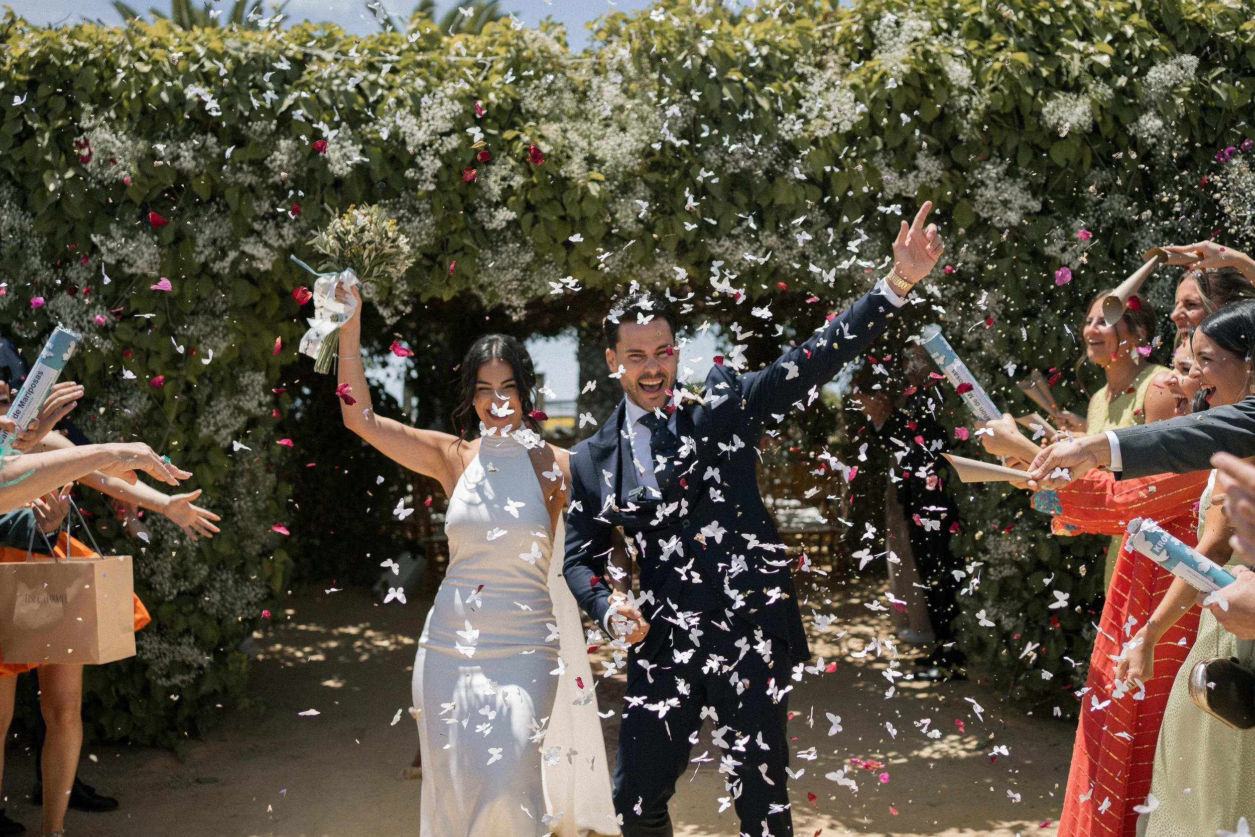 Recien casados salen de la ceremonia de la boda al aire libre con confetí en Dehesa Bolaños, Jerez de la Frontera.