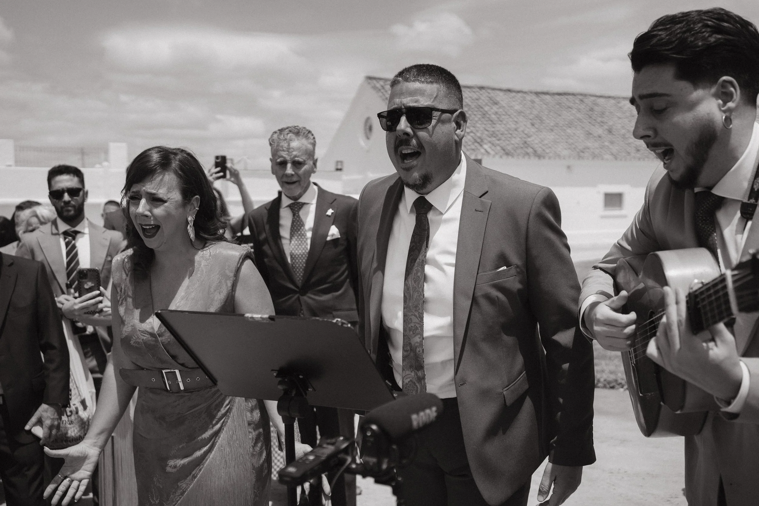 Los hermanos Pastrana cantando y tocando la guitarra en una boda al aire libre.