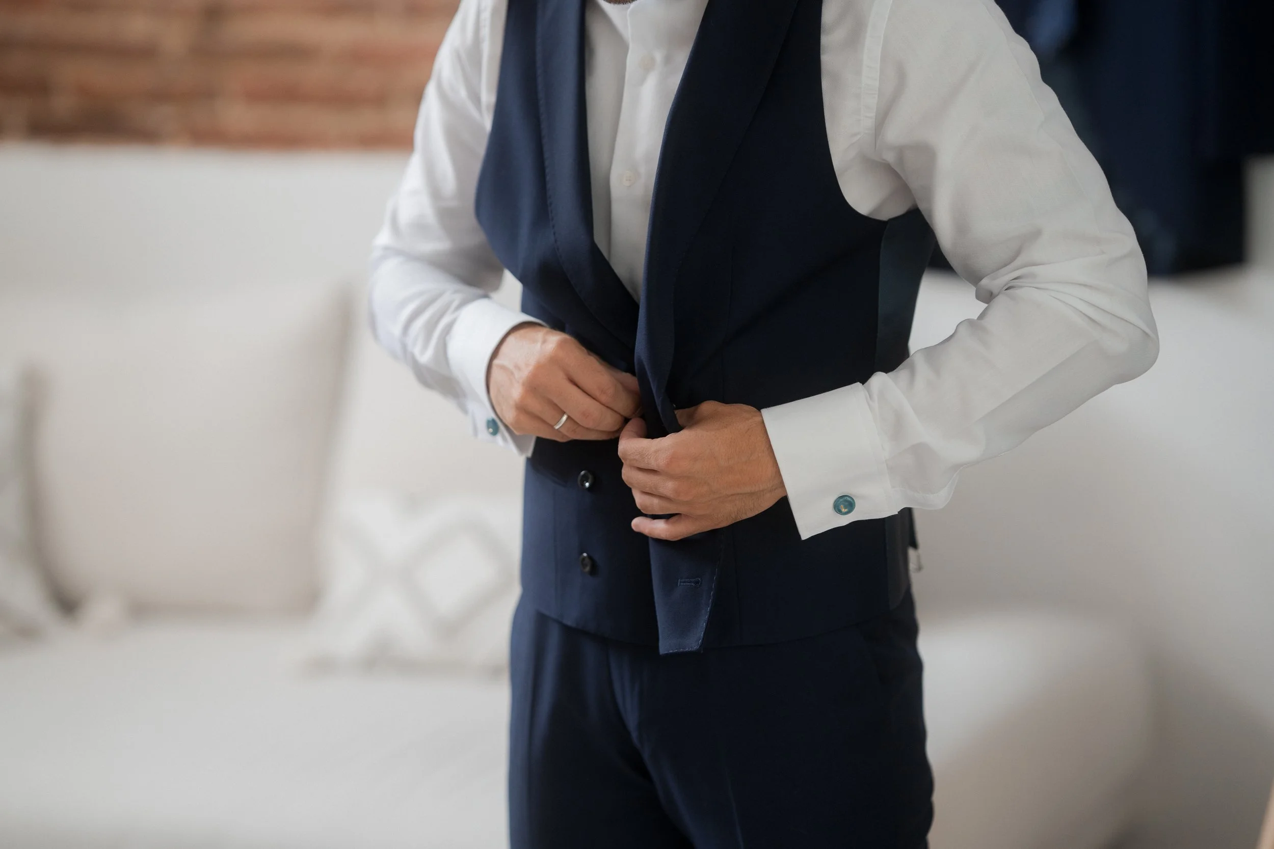 Hombre ajustándose un chaleco en un entorno interior.