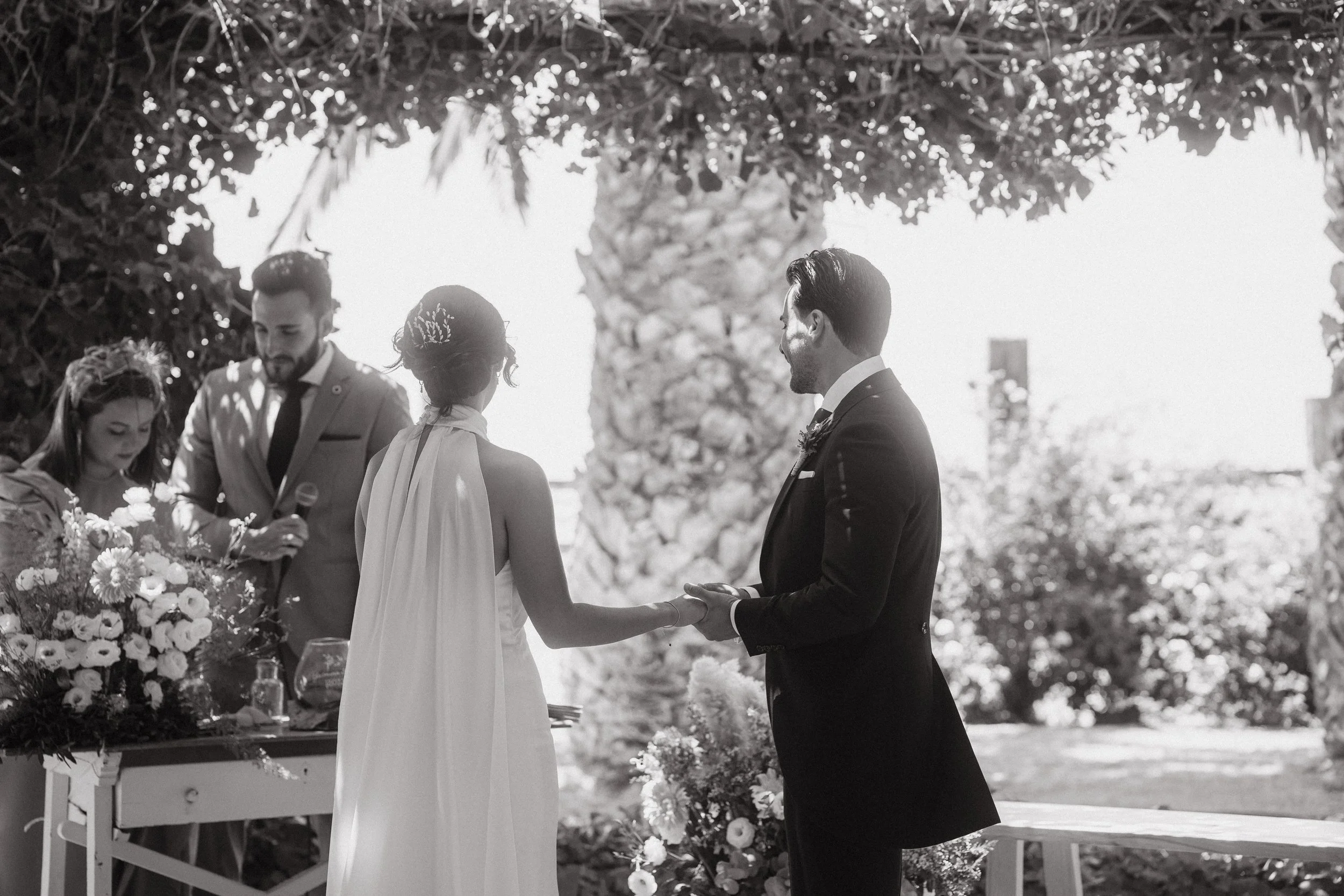 Boda en exteriores con un rey mudo en un altar rodeado de flores y árboles.
